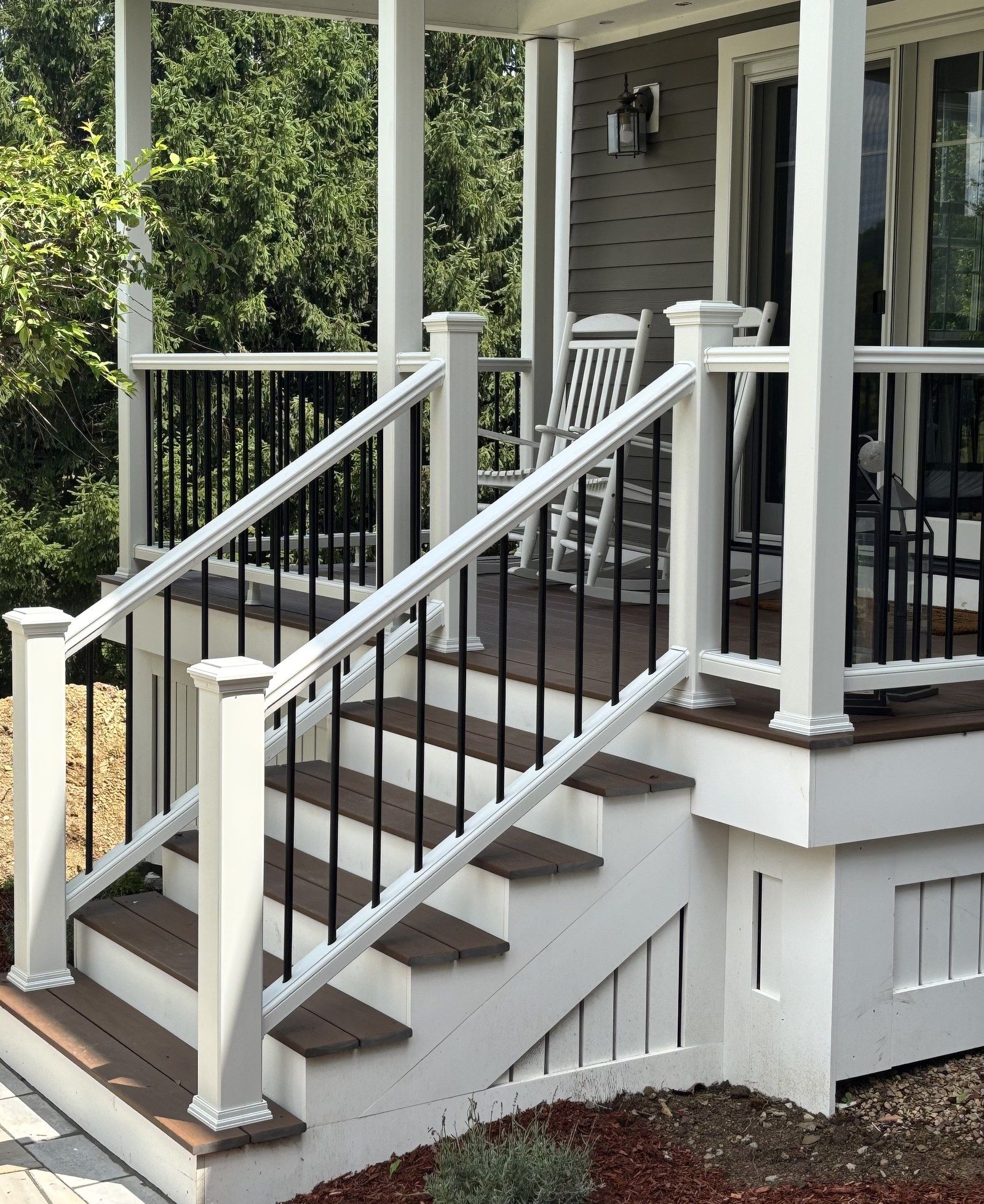 Farmer's porch with composite decking, white railings, and custom stairs built by Northeast Deck and Dock